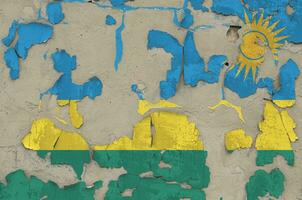 Rwanda flag depicted in paint colors on old obsolete messy concrete wall closeup. Textured banner on rough background photo