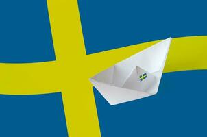 Sweden flag depicted on paper origami ship closeup. Handmade arts concept photo