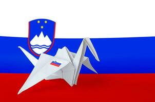 Slovenia flag depicted on paper origami crane wing. Handmade arts concept photo