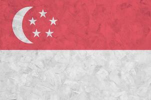 Singapore flag depicted in bright paint colors on old relief plastering wall. Textured banner on rough background photo