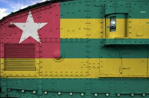 Togo flag depicted on side part of military armored tank closeup. Army forces conceptual background photo