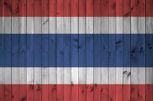 Tailandia bandera representado en brillante pintar colores en antiguo de madera pared. texturizado bandera en áspero antecedentes foto