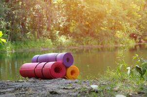 Yoga, fitness or tourist mats on the green grass outdoors photo