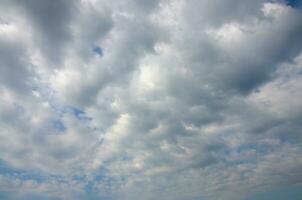 Blue sky background with white fluffy clouds in daytime outdoors photo