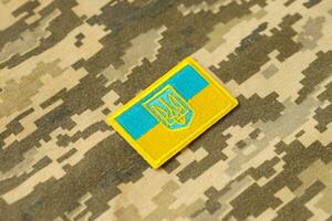 Military camouflage fabric with ukrainian flag on uniform chevron photo