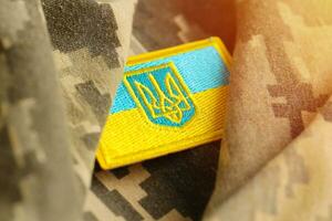 Military camouflage fabric with ukrainian flag on uniform chevron photo