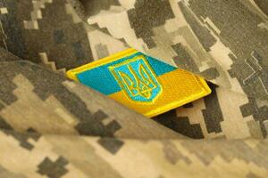 Military camouflage fabric with ukrainian flag on uniform chevron photo