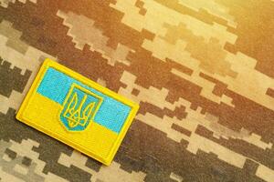 Military camouflage fabric with ukrainian flag on uniform chevron photo