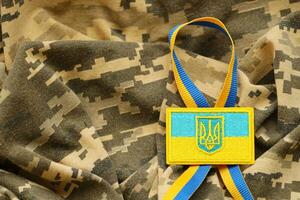 Military camouflage fabric with ukrainian flag on uniform chevron photo