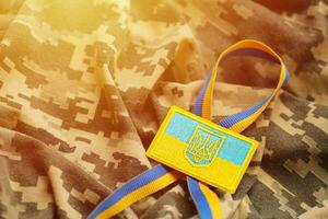 Military camouflage fabric with ukrainian flag on uniform chevron photo