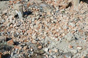 Pile of broken red bricks and fragments of concrete from destroyed building photo