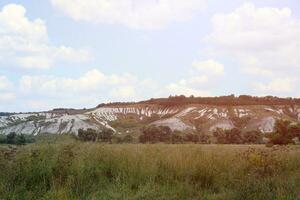 Ancient multimillion chalk mountains on the steppe surface of earth photo