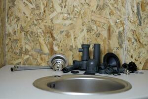 Tools and water tap ready for installation sink on countertop photo