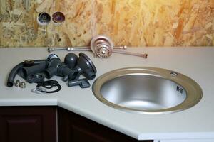 Tools and water tap ready for installation sink on countertop photo