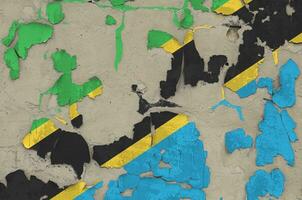 Tanzania flag depicted in paint colors on old obsolete messy concrete wall closeup. Textured banner on rough background photo