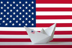 United States of America flag depicted on paper origami ship closeup. Handmade arts concept photo