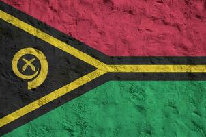 Vanuatu flag depicted in bright paint colors on old relief plastering wall. Textured banner on rough background photo