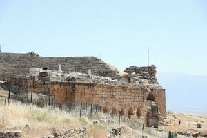 ANTALYA, TURKEY - MAY 15, 2021 Ruins of ancient city Hierapolis near Pamukkale, Turkey at sunny day. Parts of old historical buildings with big blocks photo