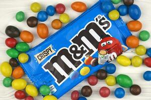 KHARKIV, UKRAINE - JANUARY 2, 2021 M and Ms colorful button shaped chocolate candies. Multi colored chocolates each of which has the letter m printed in lower case in white photo