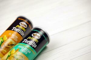 Pringles cylinder tubes with Tortilla el nacho cheese and sour cream fiesta flavour. Pringles is a brand of potato snack chips owned by Kellogg Company photo