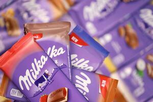 KHARKOV, UKRAINE - DECEMBER 8, 2020 Many wrappings of purple Milka chocolate. Milka is a Swiss brand of chocolate confection manufactured by company Mondelez International photo