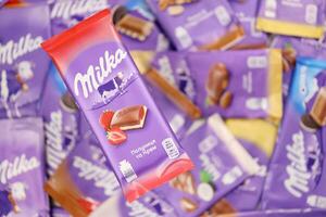 KHARKOV, UKRAINE - DECEMBER 8, 2020 Many wrappings of purple Milka chocolate. Milka is a Swiss brand of chocolate confection manufactured by company Mondelez International photo