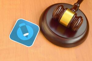 Livejournal paper logo lies with wooden judge gavel. Entertainment lawsuit concept photo