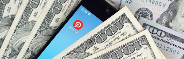 Smartphone screen with Pinterest app and lot of hundred dollar bills. Business and social networking concept photo