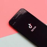 Tiktok application on samsung smartphone screen on pastel background. TikTok is a popular video-sharing social networking service owned by ByteDance photo
