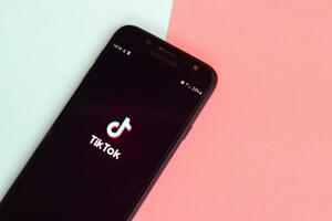 Tiktok application on samsung smartphone screen on pastel background. TikTok is a popular video-sharing social networking service owned by ByteDance photo