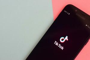 Tiktok application on samsung smartphone screen on pastel background. TikTok is a popular video-sharing social networking service owned by ByteDance photo