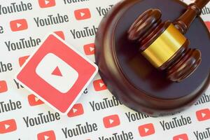 Youtube paper logo lies with wooden judge gavel. Entertainment lawsuit concept photo