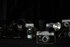 KHARKOV, UKRAINE - APRIL 27, 2021 Zenit 3m Film photo camera and another old retro photo equipment on black wooden table in photographer darkroom. Photographic gear from soviet union