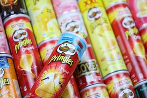 KHARKOV, UKRAINE - MARCH 30, 2021 Many Pringles cylinder chips boxes with varios colors and flavours. American brand of stackable potato-based crisps photo