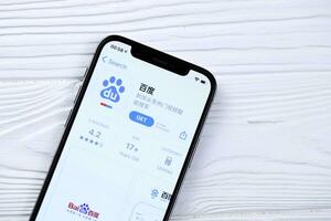 KHARKOV, UKRAINE - MARCH 5, 2021 Baidu icon and application from App store on iPhone 12 pro display screen on white table photo