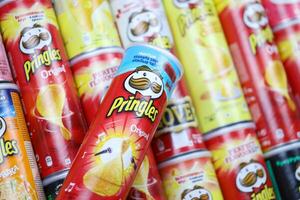 KHARKOV, UKRAINE - MARCH 30, 2021 Many Pringles cylinder chips boxes with varios colors and flavours. American brand of stackable potato-based crisps photo