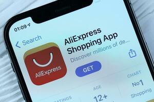 KHARKOV, UKRAINE - MARCH 5, 2021 Aliexpress icon and application from App store on iPhone 12 pro display screen on white table photo