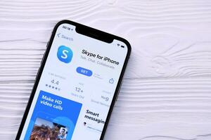 KHARKOV, UKRAINE - MARCH 5, 2021 Skype icon and application from App store on iPhone 12 pro display screen on white table photo