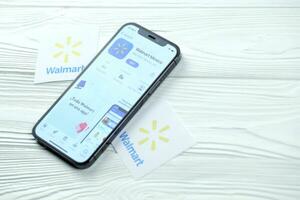 KHARKOV, UKRAINE - MARCH 5, 2021 Walmart icon and application from App store on iPhone 12 pro display screen on white table photo