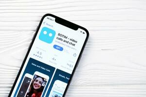 KHARKOV, UKRAINE - MARCH 5, 2021 Botim messenger icon and application from App store on iPhone 12 pro display screen on white table photo