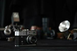 KHARKOV, UKRAINE - APRIL 27, 2021 Fed 5b Film photo camera and another old retro photo equipment on black wooden table in photographer darkroom. Photographic gear from soviet union