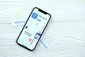 KHARKOV, UKRAINE - MARCH 5, 2021 Walmart icon and application from App store on iPhone 12 pro display screen on white table photo