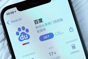 KHARKOV, UKRAINE - MARCH 5, 2021 Baidu icon and application from App store on iPhone 12 pro display screen on white table photo