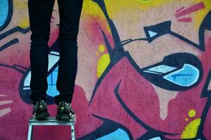 KHARKOV, UKRAINE - MAY 27, 2017 Festival of street arts. Young guys draw graffiti on portable wooden walls in the center of the city. The process of painting on walls with aerosol spray cans photo