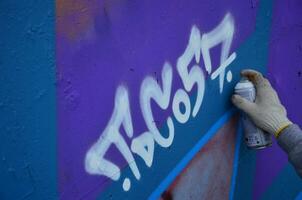 KHARKOV, UKRAINE - MAY 27, 2017 Festival of street arts. Young guys draw graffiti on an old concrete walls in the center of the city. The process of painting on walls with aerosol spray cans photo