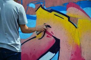 KHARKOV, UKRAINE - MAY 27, 2017 Festival of street arts. Young guys draw graffiti on portable wooden walls in the center of the city. The process of painting on walls with aerosol spray cans photo