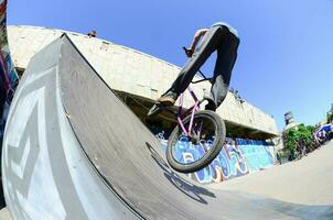 kharkiv, ucrania - 27 de mayo de 2018 ciclistas de bmx freestyle en un skatepark durante el festival anual de culturas callejeras foto