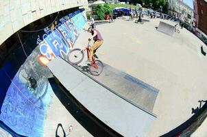 kharkiv, ucrania - 27 de mayo de 2018 ciclistas de bmx freestyle en un skatepark durante el festival anual de culturas callejeras foto