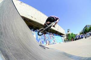 KHARKIV, UKRAINE - 27 MAY, 2018 Freestyle BMX riders in a skatepark during the annual festival of street cultures photo