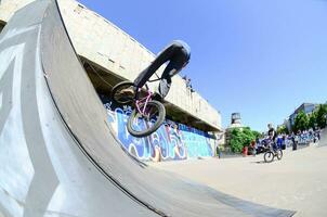 kharkiv, ucrania - 27 de mayo de 2018 ciclistas de bmx freestyle en un skatepark durante el festival anual de culturas callejeras foto